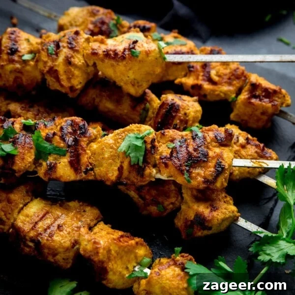 Creamy Coconut Curry Sauce Recipe for Authentic Flavor 8 chicken tikka skewers on a dark background