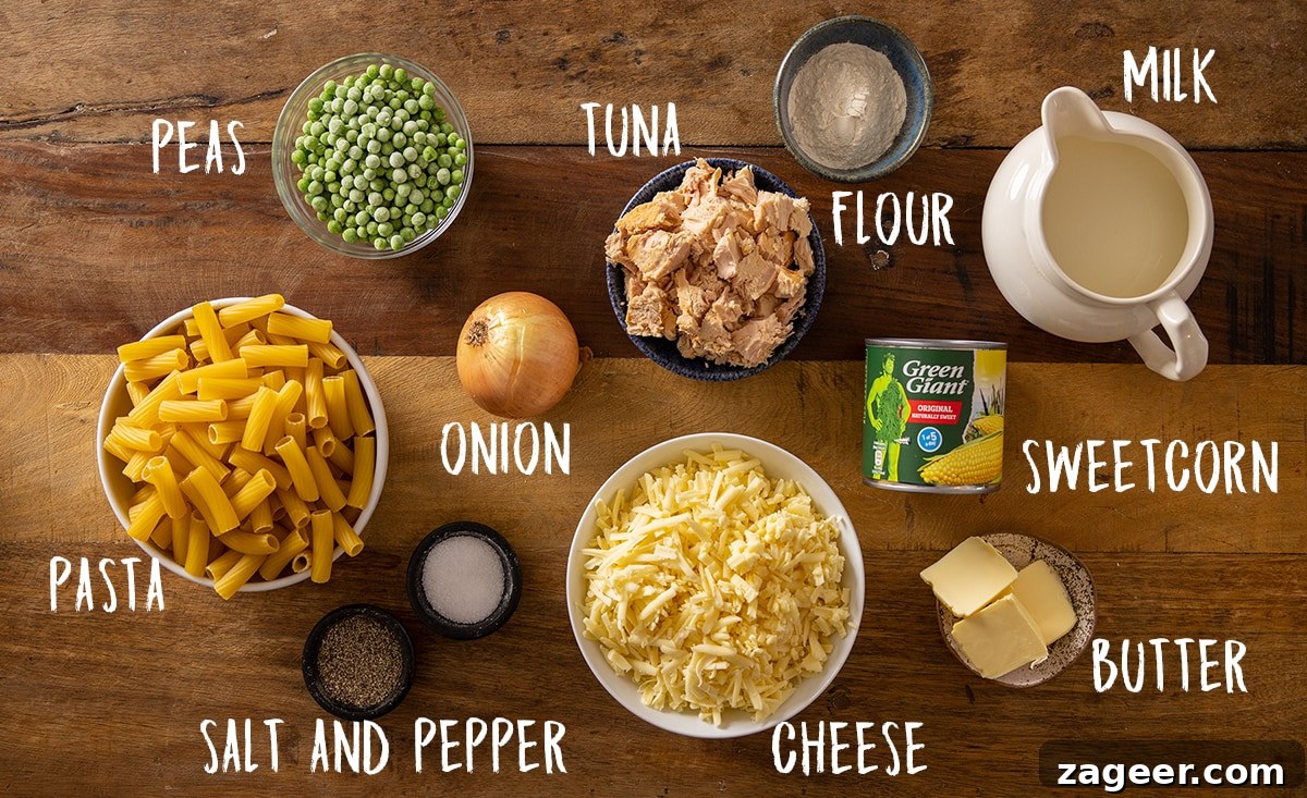 Creamy Tuna Pasta Bake with Cheesy Golden Crust 3 Overhead picture of Tuna Pasta Bake ingredients on a wooden background.