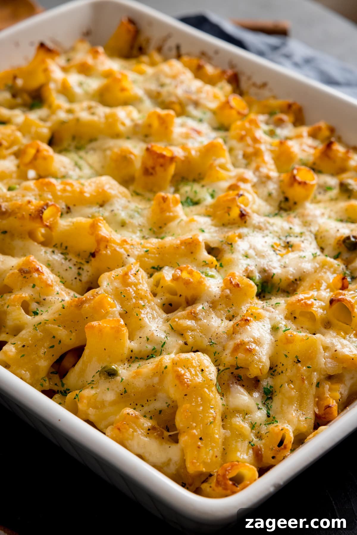 Creamy Tuna Pasta Bake with Cheesy Golden Crust 4 Close up of creamy tuna pasta bake in a white baking dish.