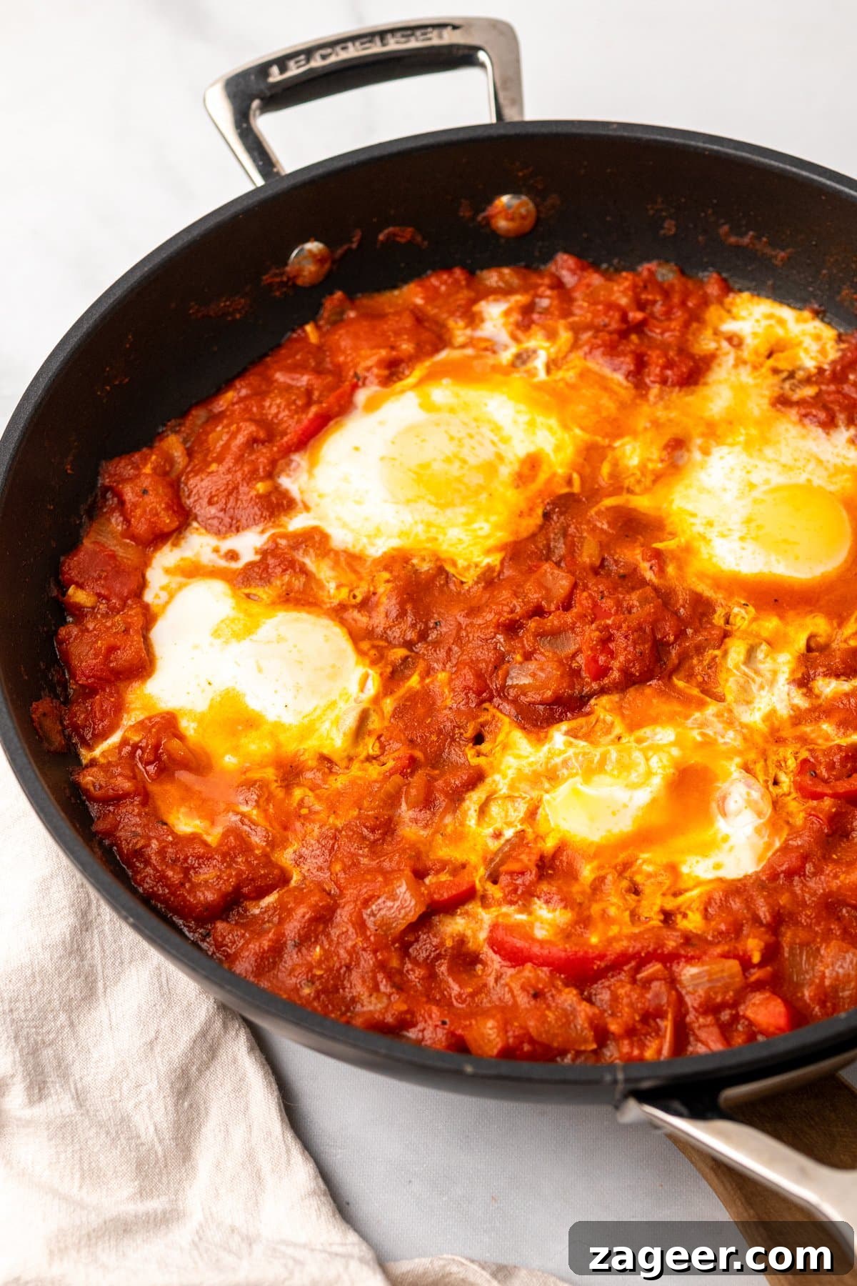 Mexican Shakshuka Recipe: Spicy Southwest Eggs in Tomato Sauce 4 Shakshuka in a pan on a light background.