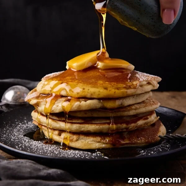 Cinnamon French Toast Recipe: Crispy, Custardy Morning Toast 10 A stack of six fluffy pancakes with butter and syrup being poured.