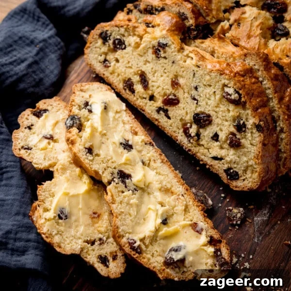Cinnamon French Toast Recipe: Crispy, Custardy Morning Toast 9 Sliced fruit soda bread with butter rests on a wooden surface.