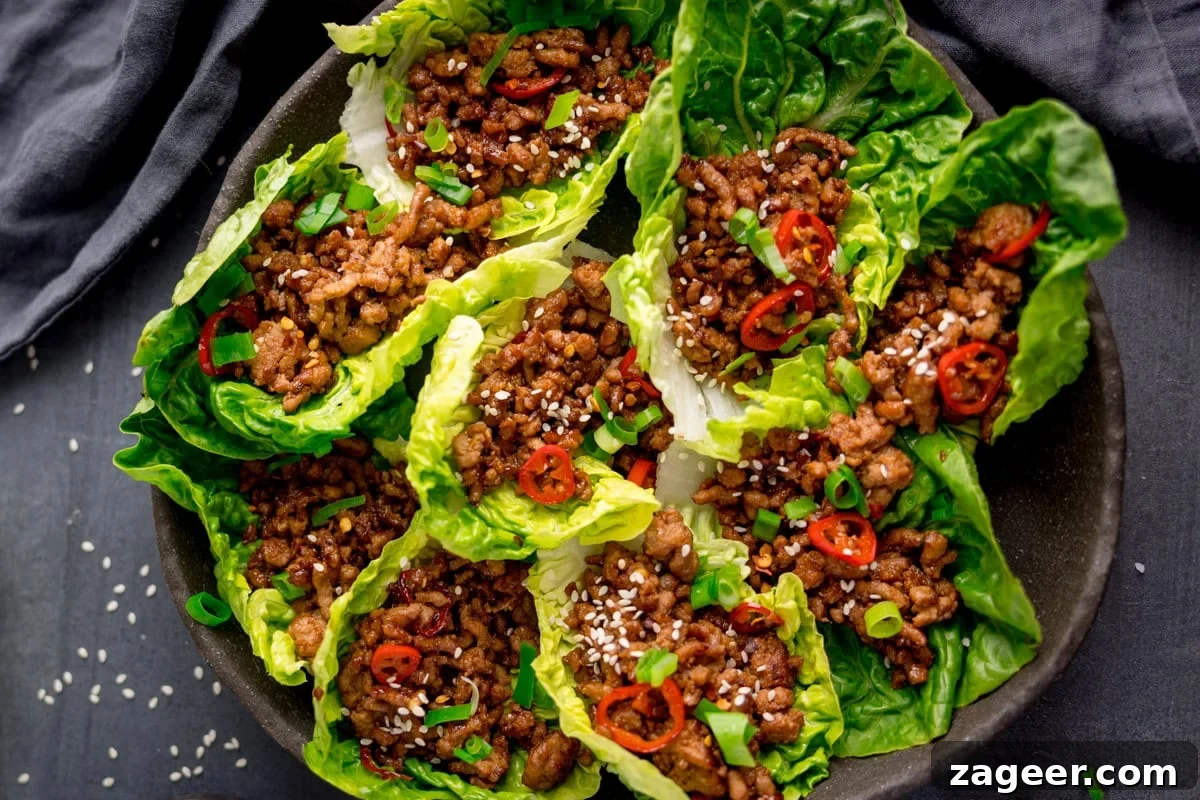 Turkey Lettuce Wrap Recipe: Flavorful Low-Carb Meal Ideas 5 A plate of Turkey Lettuce Wraps filled with cooked minced turkey, sliced red chilli, chopped spring onions, and sprinkled with sesame seeds.