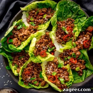Turkey Lettuce Wrap Recipe: Flavorful Low-Carb Meal Ideas 6 A plate of turkey lettuce wraps filled with savoury minced meat, garnished with sliced red chilli, spring onions, and sesame seeds.