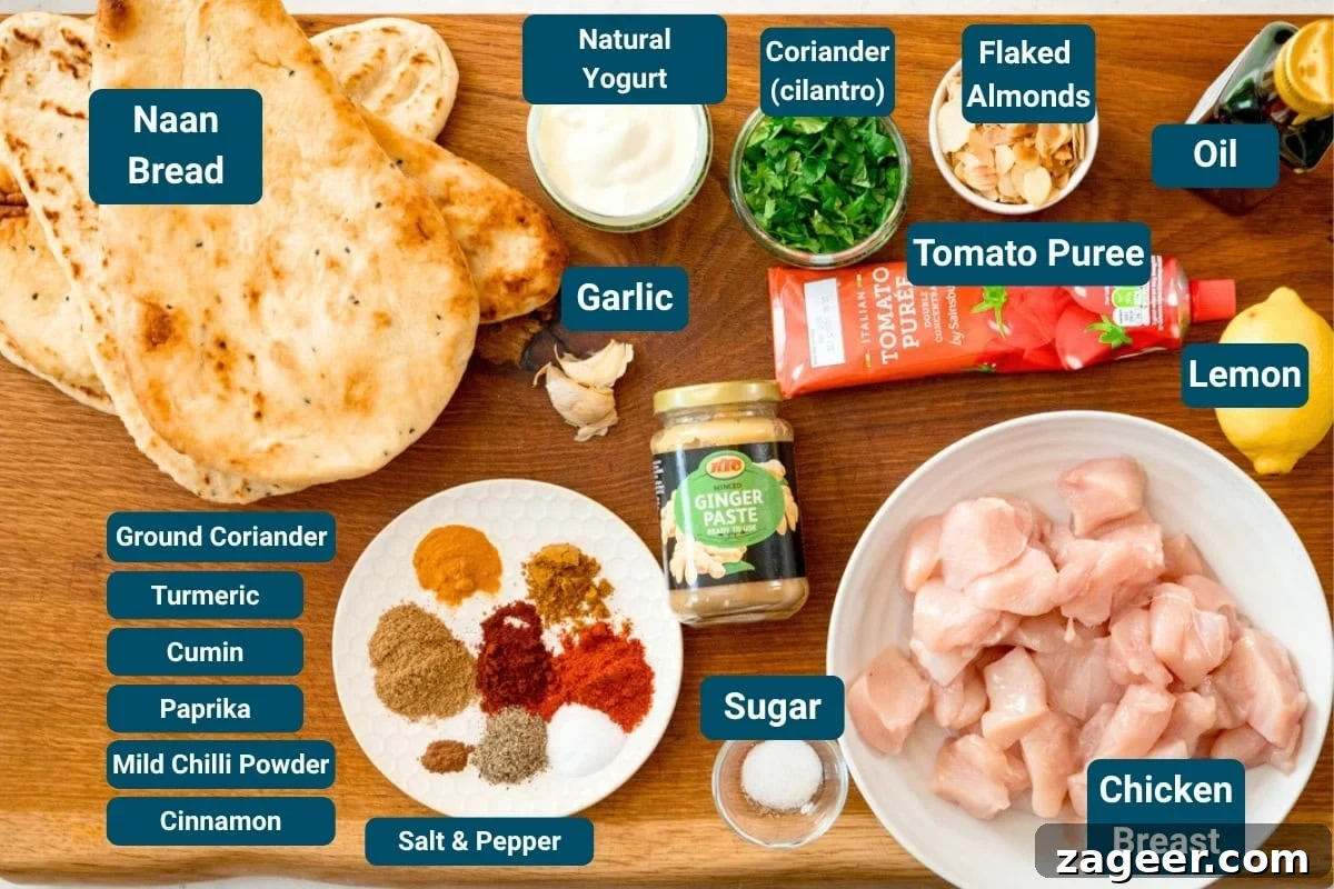 Chicken Tikka Pizza Recipe: Crispy Homemade Tandoori-Style Pizza 3 A wooden board with labelled ingredients for naan bread chicken pizza including naan bread, raw chicken, spices, ginger purée, tomato purée, yoghurt, parsley, flaked almonds, lemon, garlic, and seasonings.