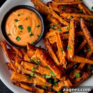 Crispy Baked Parmesan Carrot Fries Recipe 9 Carrot fries on a white plate with dipping sauce