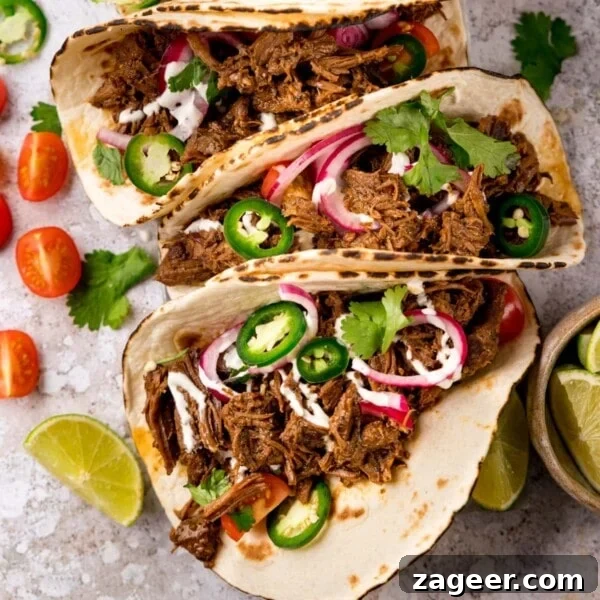 Quick Chicken Fajitas with Peppers and Onions 7 Square image of beef barbacoa on soft tacos topped with red onion and jalapeno slices
