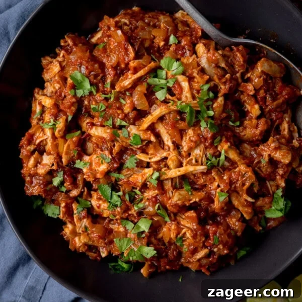 Quick Chicken Fajitas with Peppers and Onions 8 A square, overhead shot of chicken tinga in a large black bowl.