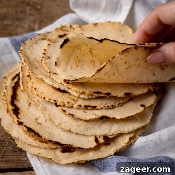 Quick Chicken Fajitas with Peppers and Onions 9 A stack of corn tortillas being folded by hand.