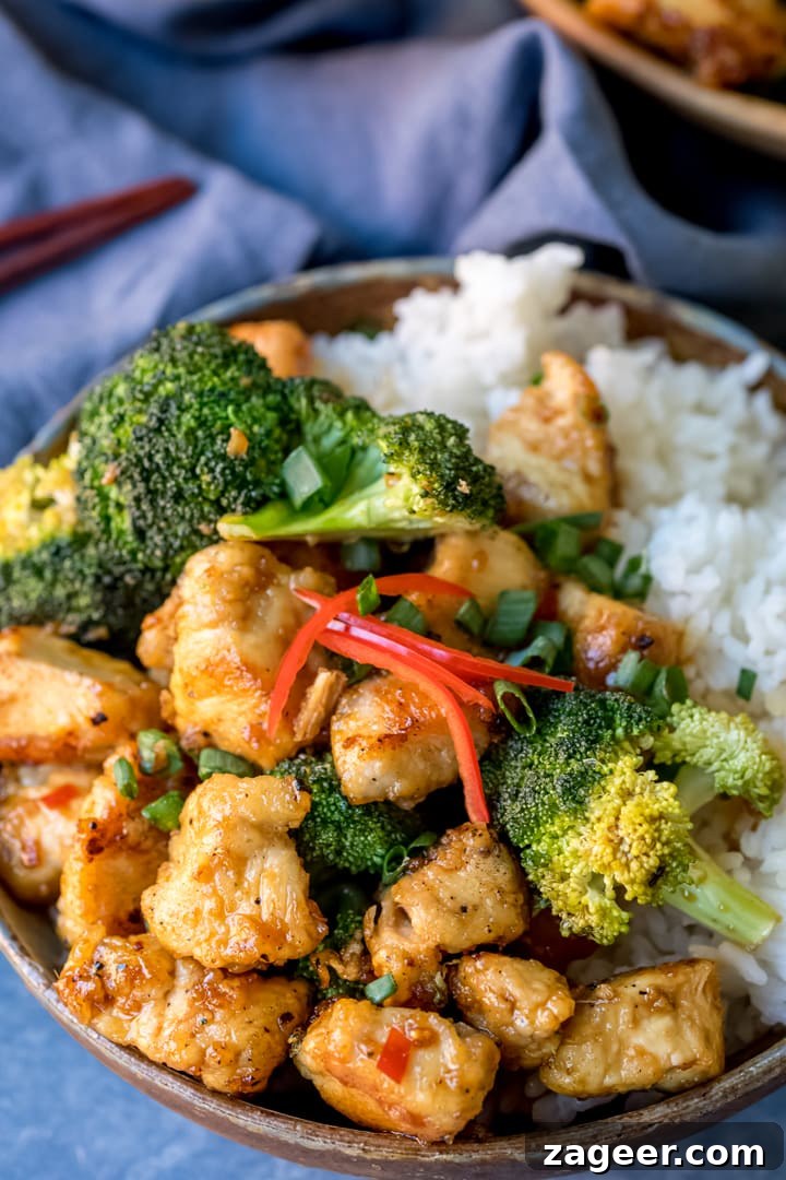 Crispy chicken with broccoli and rice in a bowl with blue background