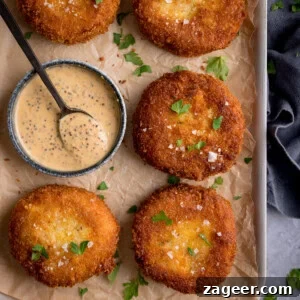 Crispy Tuna Fish Cakes with Lemon-Dill Sauce 8 Four breaded, fried tuna fish cakes garnished with parsley are arranged on baking parchment beside a small bowl of creamy mustard sauce with a spoon.