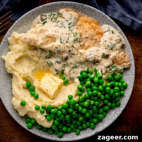 Steak Fries with Creamy Peppercorn Sauce 14 Plate with lemon butter sea bream in creamy sauce, mashed potatoes with butter, and green peas on a grey dish.