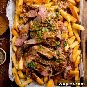 Steak Fries with Creamy Peppercorn Sauce 10 A tray of golden chips topped with sliced steak, creamy Peppercorn Sauce, and chopped parsley.