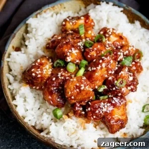 Crispy Sesame Chicken with Sticky Sweet-Savory Asian Sauce 5 Crispy Sesame Chicken on a bed of rice in a stone bowl