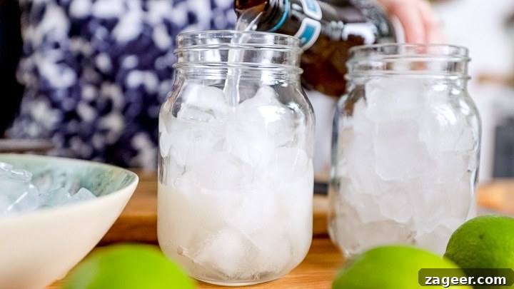 Dark ’N’ Stormy Cocktail Recipe: Classic Rum & Ginger Mix 3 Pouring ginger beer into a glass full of ice