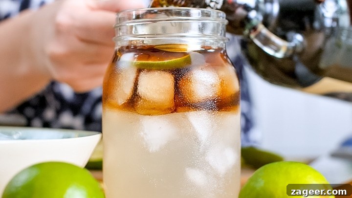 Dark ’N’ Stormy Cocktail Recipe: Classic Rum & Ginger Mix 5 Pouring rum into a glass filled with ice and ginger beer