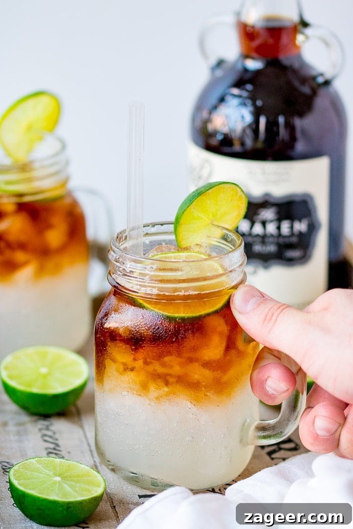 Dark ’N’ Stormy Cocktail Recipe: Classic Rum & Ginger Mix 7 Hand holding a glass of dark and stormy cocktail