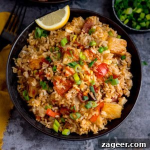 A black bowl filled with Ham and Pineapple Fried Rice with diced vegetables, pineapple chunks and spring onions