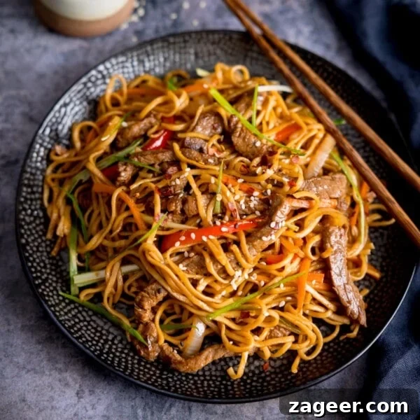 Spicy Pork Curry Ramen Recipe for Bold Flavor 11 Square image of beef teriyaki noodle stir fry on a black plate.