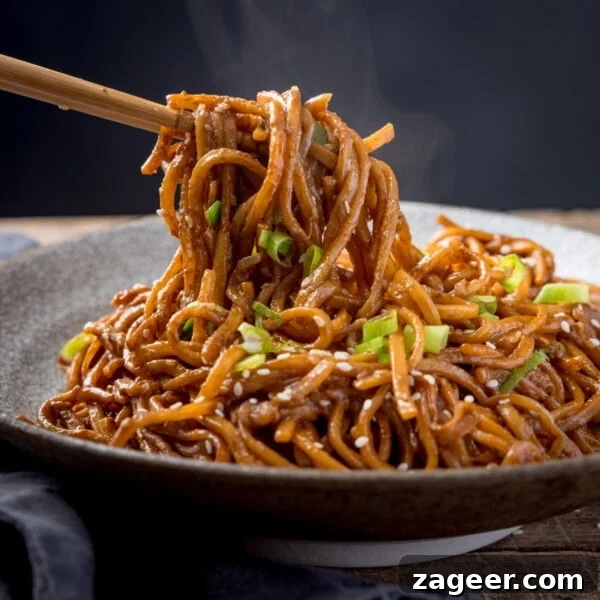 Spicy Pork Curry Ramen Recipe for Bold Flavor 12 Square image of sesame noodles in a bowl, topped with spring onions and sesame seeds.