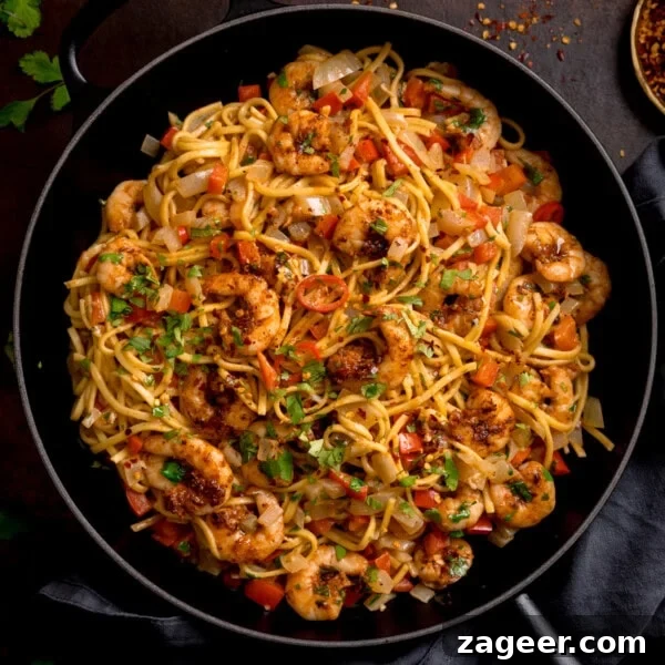 Spicy Pork Curry Ramen Recipe for Bold Flavor 13 A frying pan filled with king prawn stir-fry noodles.