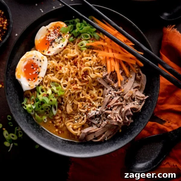 Spicy Pork Curry Ramen Recipe for Bold Flavor 9 A black bowl of Peanut Butter Ramen with sliced beef, soft-boiled eggs, spring onions, shredded carrots, and sesame seeds, with chopsticks resting on the rim.