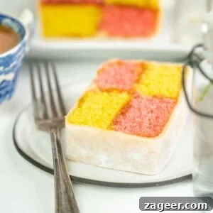 Perfect Battenberg Cake Recipe: Step-by-Step Guide 13 Battenberg cake slice on a plate with a fork on a light background.