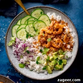 11 Fresh Spring Dinners Ready in 30 Minutes or Less 5 A bowl of white rice topped with cooked honey garlic prawns, sliced cucumber, chopped red onion, diced avocado, fresh coriander, and sesame seeds.