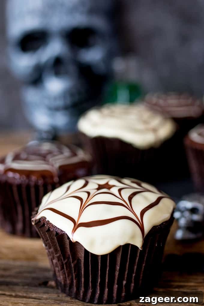 Spider Web Chocolate Cupcakes for Halloween Parties 2 Close up of a chocolate Halloween cupcake with a spiderweb pattern on top.