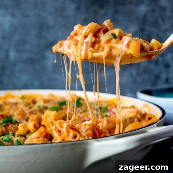 One-Pot Chicken and Broccoli Pasta Dinner in 30 Minutes 13 Spoonful of chicken and bacon mac and cheese being scooped from a pan.