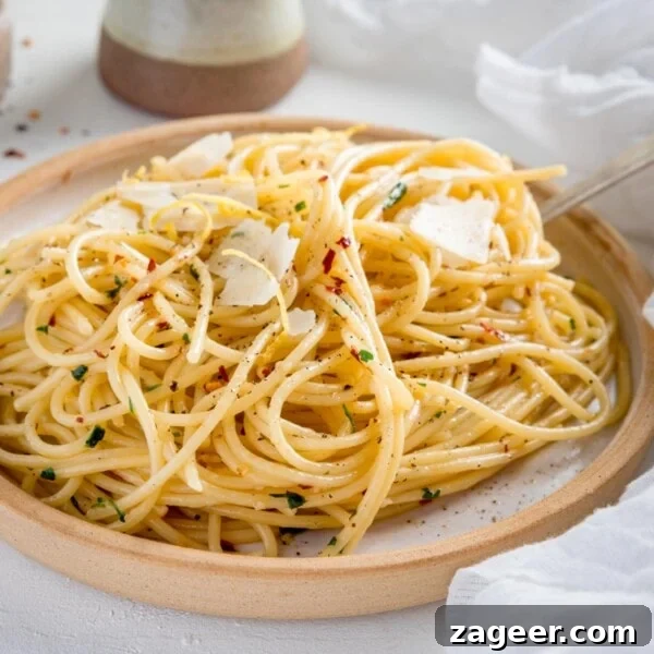 One-Pot Chicken and Broccoli Pasta Dinner in 30 Minutes 8 Square image of Spaghetti aglio e olio on white plate with stone rim.