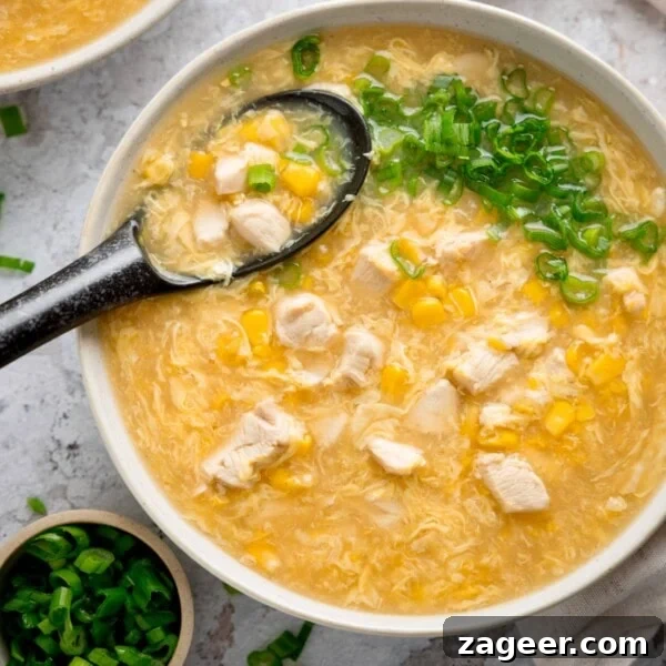 Hearty Pulled Pork and White Bean Soup Recipe 7 Overhead square shot of a white bowl filled with chicken and sweetcorn soup.