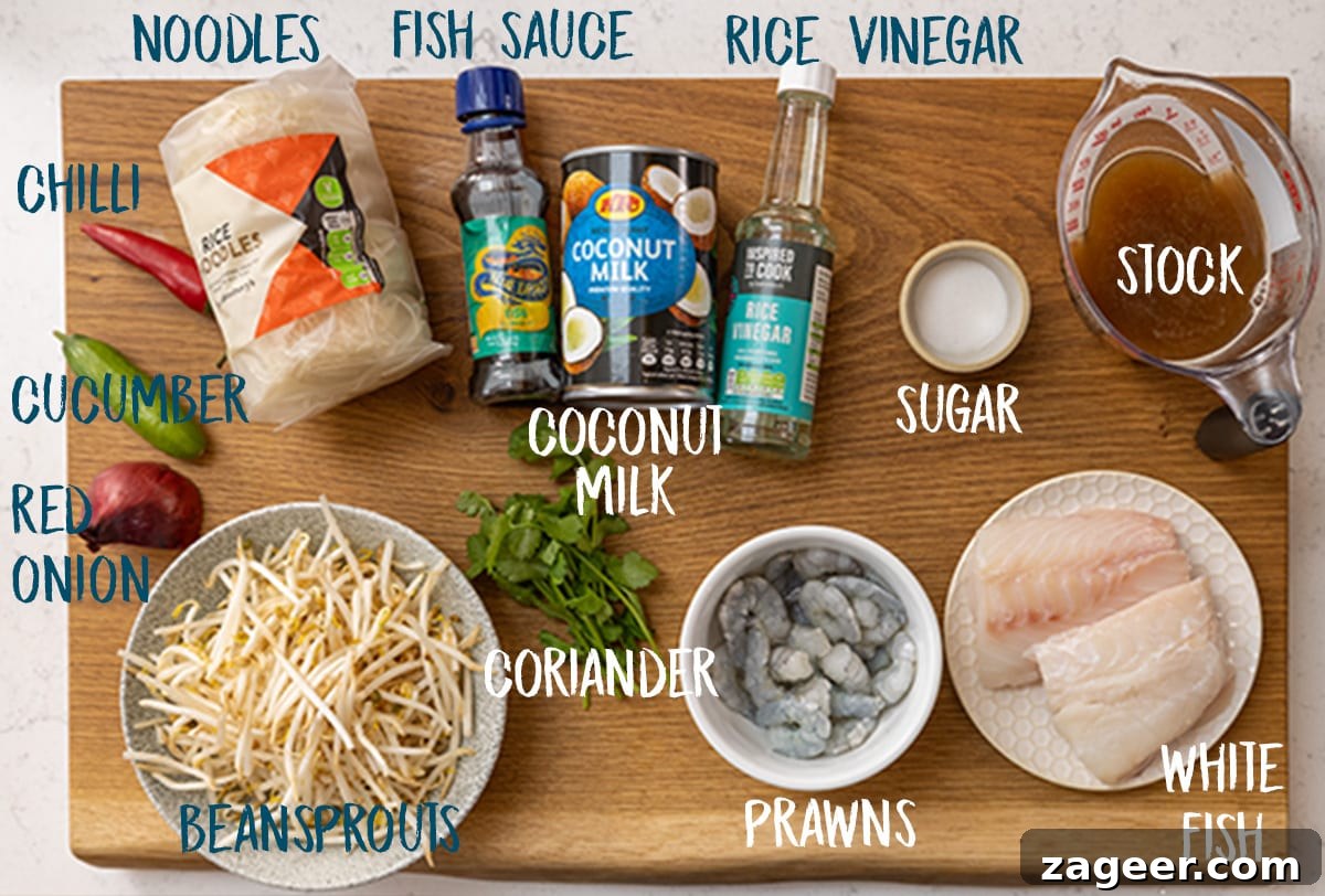 Creamy Seafood Laksa Recipe: Authentic Malaysian Coconut Noodle Soup 4 Ingredients for seafood laksa (except for the laksa paste, which is in another image) on a wooden board.