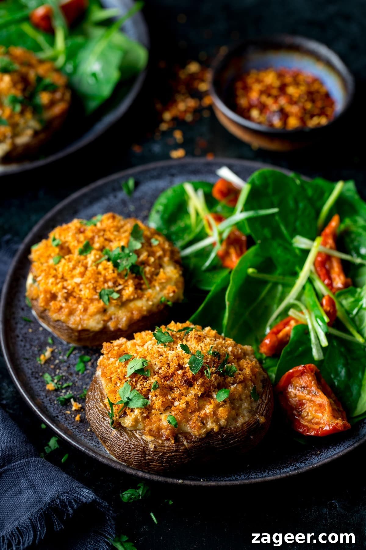 Cheesy Garlic Stuffed Mushrooms Recipe for Entertaining 2 Stuffed mushrooms with salad on a dark plate