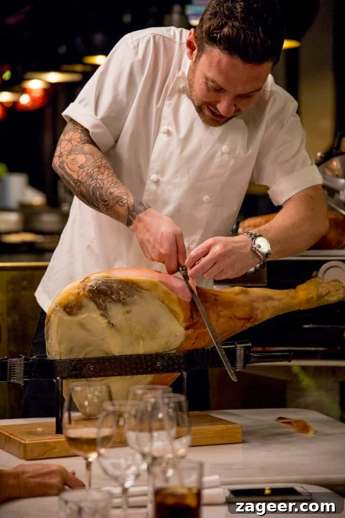 Herb Yorkshire Puddings with Grana Padano Béchamel & Prosciutto di San Daniele 5 Chef slicing Proscuitto di San Daniele at an event
