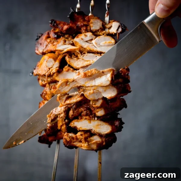 Marinated, grilled chicken doner being sliced