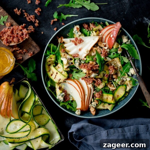 Grilled courgette, bacon and pear salad in a blue bowl.