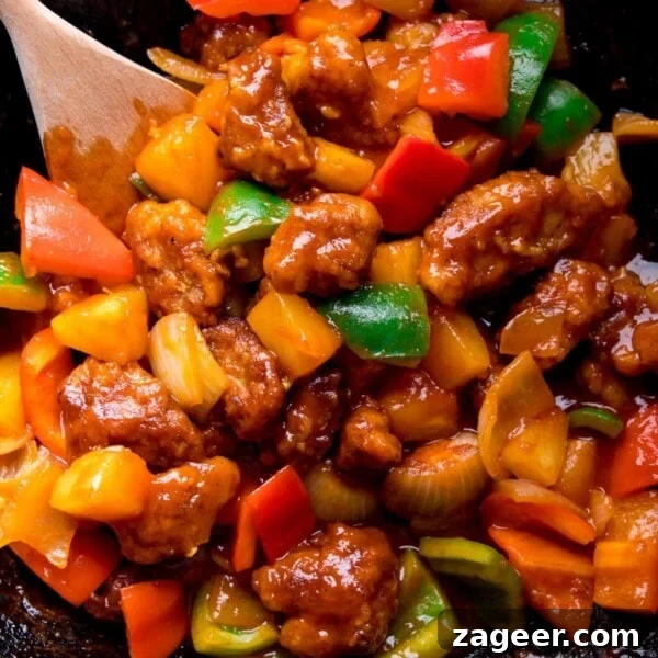 Sweet and sour pork with peppers in a wok.